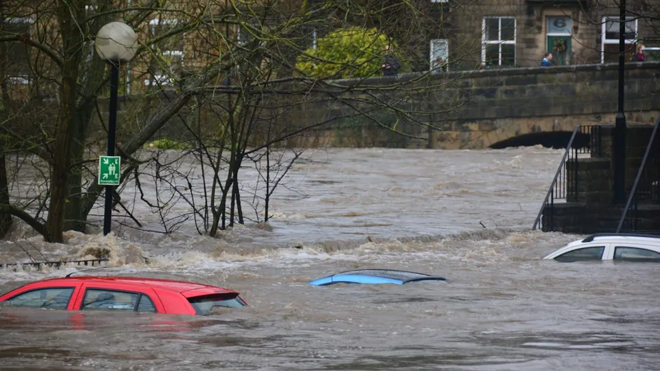 Floodwater through a street with vehicles submerged